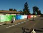 long shot view of colorful mural painted onto 500' fence