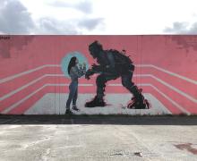 street view of a mural with a woman and a monster together in a boxing ring
