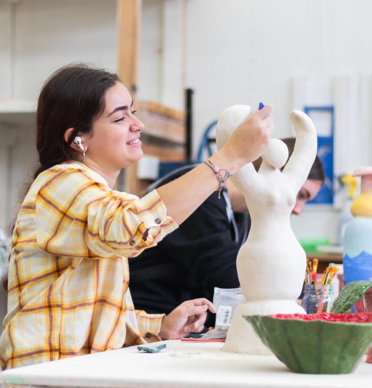 student doing art smiling
