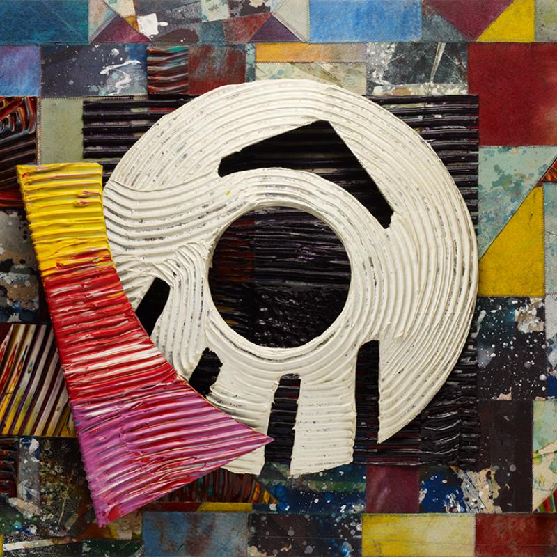Abstract mixed-media artwork featuring a collage of colorful geometric shapes in red, yellow, blue, and maroon tones. At the center is a large white circular form with black angular markings resembling an eye or target. The piece combines layered textures and dynamic color contrasts, creating a sense of rhythm and motion