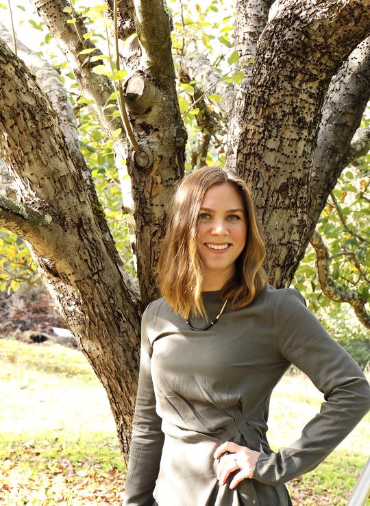 Kara de Lambert with hand on hip standing in front of a tree