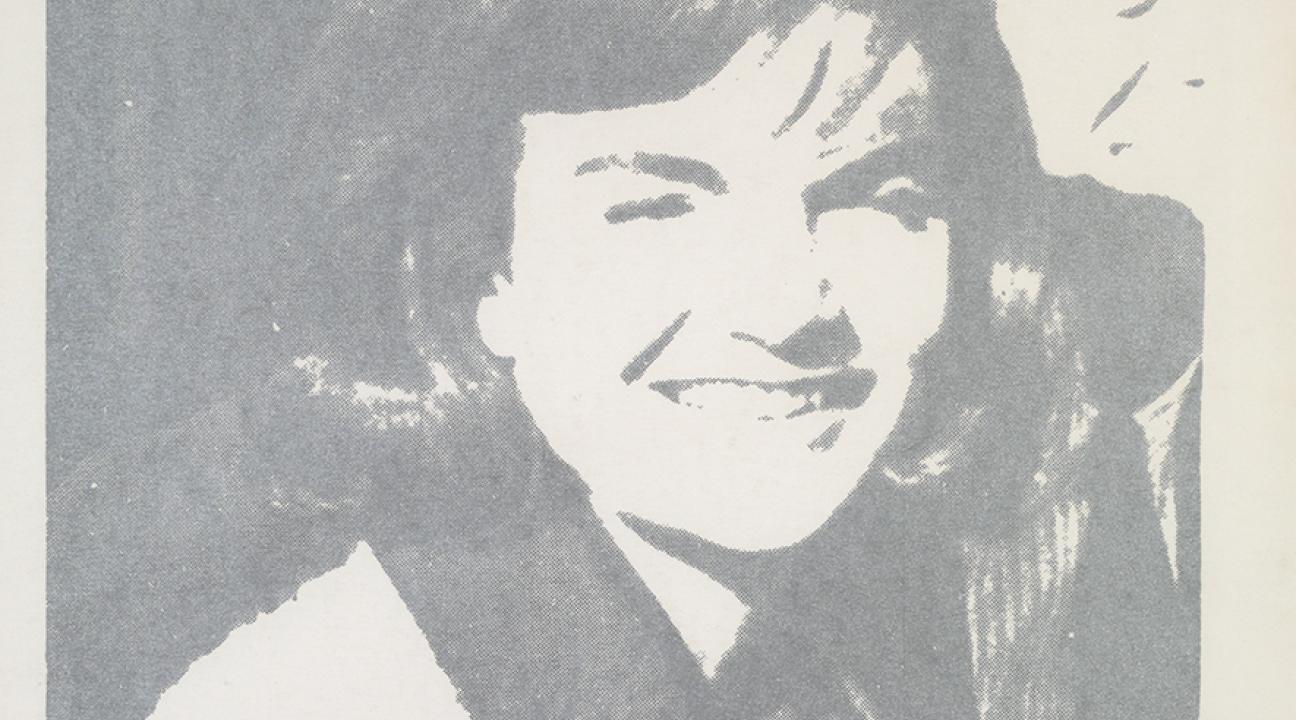 Silkscreen portrait in gray tones showing a smiling woman wearing a hat and coat, rendered in a simplified, high-contrast style. The image has a flat, graphic quality typical of Andy Warhol’s pop art portraits, emphasizing celebrity imagery and mass reproduction