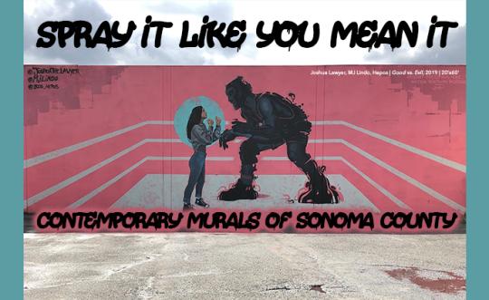 A mural showing a large black-and-white figure of a man spray-painting a red heart onto a wall, facing a small child holding a flower. The text at the top reads ‘SPRAY IT LIKE YOU MEAN IT,’ and below, it says ‘CONTEMPORARY MURALS BY JORDAN CROWE.’ The ground in front of the mural is concrete
